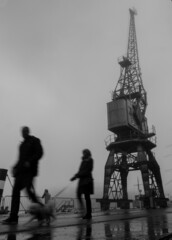 Naklejka na ściany i meble blurred, silhouetted figures walking in bristol docks