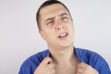 An office worker in a blue shirt looks at the camera. He covered in sweat stains. The man has a lot...