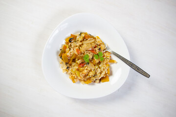 spicy rice with vegetables in bowl on white background
