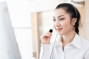 Asian call center woman worker at work. Female customer support operator with headset working in the office. Contact center and customer service by headphone concept