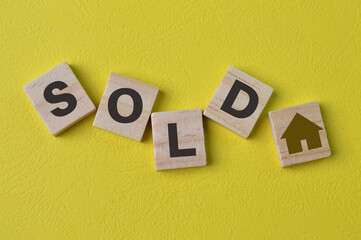 Wooden blocks with home symbol and the words SOLD