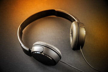 Fototapeta na wymiar Headphones isolated on a black and orange background