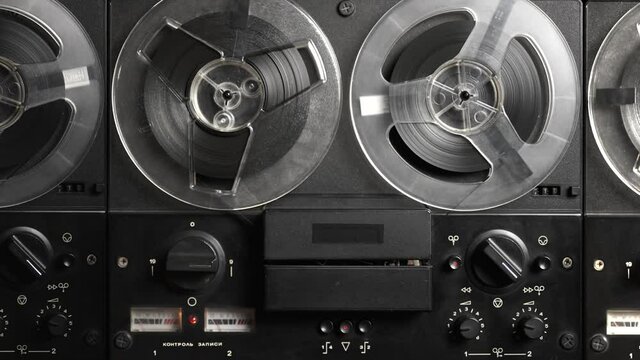Vintage tape recorder roller. Reel film tape is rotating at a oldschool professional player. Concept of spying and recording a phone conversations. Inscription in Russian: recording control