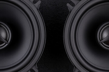 Stylish car audio acoustic round speakers on dark black background closeup
