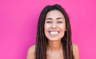 Young mixed race woman with braids smiling on camera with pink background - Concept of happiness