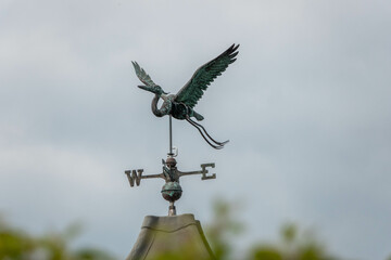 iron weathervane in the shape of a stork with a blurred background an instrument used for showing the direction of the wind - obrazy, fototapety, plakaty