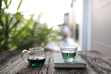 butterfly pea tea and teapot with notebook on grunge table