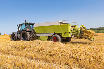 Tractor with straw baler on the harvested grain field 5620