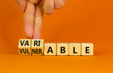 Vulnerable or variable symbol. Businessman turns wooden cubes and changes the word Vulnerable to...