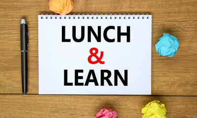 Lunch and learn symbol. Words 'Lunch and learn' on white note on beautiful wooden table, colored...