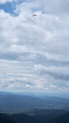 Paraglider high above the ground in the clouds