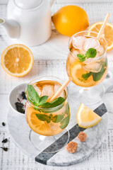Traditional iced tea with lemon and ice in tall glasses on marble table background Iced tea with lemon. Selective focus. Refreshment cold summer drink.
