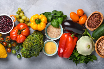 Assortment of fresh fruits and organic multicolored rainbow vegetables on gray concrete background. Food cooking and healthy clean food background and mock up.