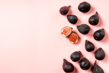 Fresh ripe figs in a plate. Beautiful blue violet fruit on pastel pink background. Healthy Mediterranean fig fruit. Copy space for text. Top view. Vegan concept