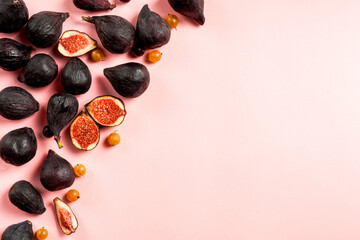 Fresh ripe figs in a plate. Beautiful blue violet fruit on pastel pink background. Healthy Mediterranean fig fruit. Copy space for text. Top view. Vegan concept