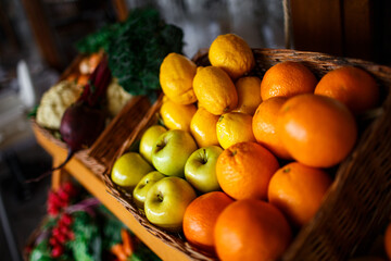 basket with lemons, oranges and apples on the counter in a supermarket close-up