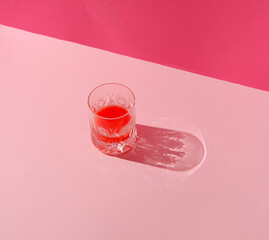 Authentic summer layout made with a glass of drink on a pastel pink background. Creative minimal concept.