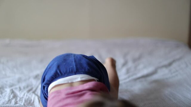 Happy baby toddler jumping into bed