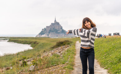 A young tourist walking from Point de Vue towards the Abbey of Mont Saint-Michel, Normandy region, France