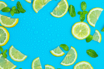 Frame from lemon slices and mint leaves on blue pastel table top view. Ingredients for summer drink and lemonade. Flat lay style