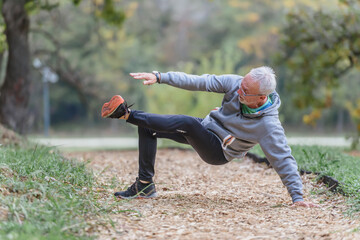 Senior older man exercising alone in the park