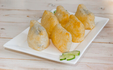Japanese inari-zushi with rice and tofu on a white plate