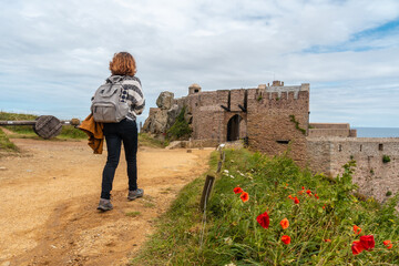 A young tourist visiting Castle Fort-la-Latte by the sea at Cape Fréhel and near Saint-Malo, Plevenon peninsula, French Brittany. France