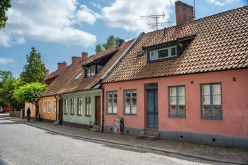 Fototapeta na wymiar Lund, Sweden - July 2021: Characteristic Strolling streets and alleys with old Picturesque Buildings in downtown of Small travel friendly Town Lund In Skane, Sweden.