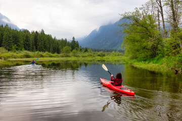 Adventure Friends Kayaking in Kayak surrounded by Canadian Mountain Landscape. Taken in Widgeon Valley, Pitt Meadows, Vancouver, British Columbia, Canada.