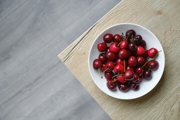 A bowl of organic sweet cherries on the table. The concept of proper nutrition, diet and lifestyle. Juicy berry close-up. Vegetable food. Fresh vitamins. Organic eco product, farm. Without GMO