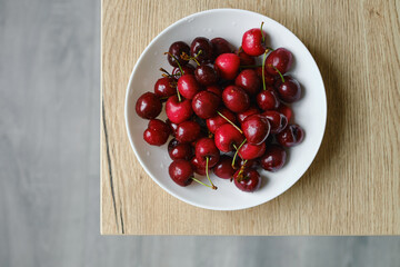 A bowl of organic sweet cherries on the table. The concept of proper nutrition, diet and lifestyle. Juicy berry close-up. Vegetable food. Fresh vitamins. Organic eco product, farm. Without GMO