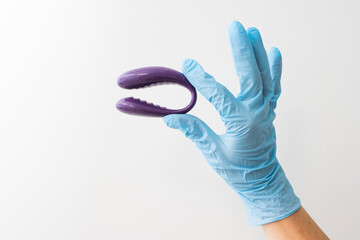 sex toy for adults in gloved hand isolated on white