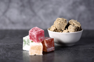 white bowl of halva and a pile of Turkish delight isolated on gray background