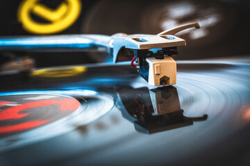 Close-up of the needle plowing through the grooves of a vinyl record on a record player.
