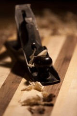 Antique hand planer on top of a butcher block with wood shavings.