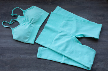 Sport woman clothes on wooden background.