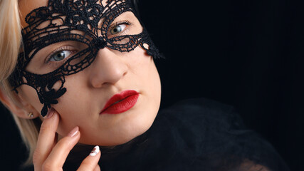 Fototapeta premium Model wearing A Masquerade Mask and red lipstick. Closeup headshot. Mysterious girl wearing a Venetian Masquerade mask. Concept of masquerade ball costume party. Isolated shot. 