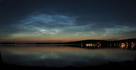 Noctilucent clouds with reflections on water. these clouds are on altitude of about 80 km and reflect the sunlight after/before sunset.