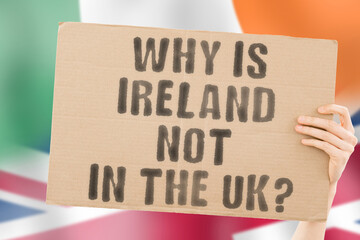 The question " Why is Ireland Not in the UK? " on a banner in men's hand with blurred Irish and British flag on the background. Freedom. Democracy. Government. Power. Territory. History. Politics