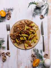 Russian cuisine fried potatoes with mushrooms on a wooden table