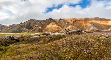 Panoramic view on moss stony hills and rocks of Multicolored mountains range at Landmannalaugar,...
