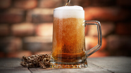 Pouring beer into pint, stylish brick wall on background.