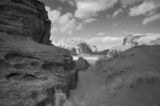 black and white photo of the Wadi Rum desert in Jordan, beautiful relief mountains, the sky with clouds, contrasting shadows on the ground