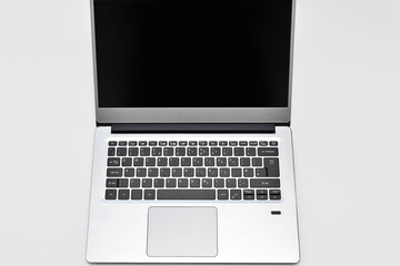 Portable modern computer laptop with black screen, touchpad and keyboard for writing text. Notebook for online remote working, video conference and chatting on the internet.