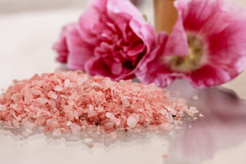 Fototapeta na wymiar Sea salt, pink blossoms on white background. Body care, Spa background . Copy space, stock photo