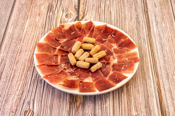 One of the most popular Spanish tapas of all time. A good plate of Iberian ham well cut by a specialist in the matter of cutting and with some bread rustic picos in the center.
