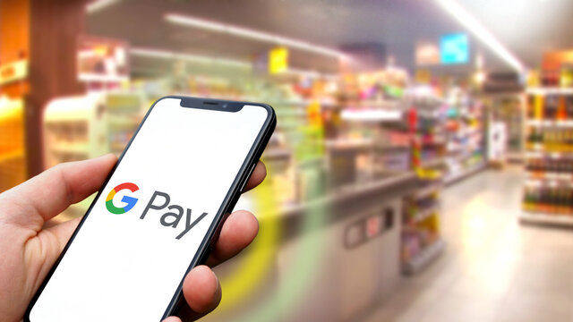 Payment with a smartphone using Google Pay in the grocery store, consumer, online banking, fintech, digitization, internet, contactless payment, shopping cart