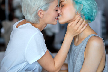 Loving Sexy Young Female Couple Hugging Kissing On Bed At Home Together, Passionate Sensual Women With Short Hair Enjoy Being In Love With Each Other, Side View Close-up Kissing. Lgbt Concept