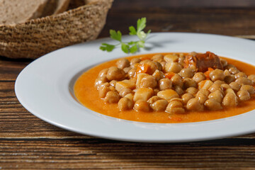Chickpea stew dish, cocido madrileño. With beef, sausage (chorizo), bacon, carrots and bread.