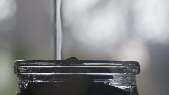 Macro, Jet Boiling Water Pours into glass Jar to the Edges Filled with Sliced Zucchini for Marinade